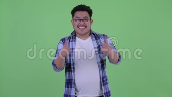 快乐的年轻超重的亚洲时髦男人竖起大拇指看上去很兴奋视频的预览图