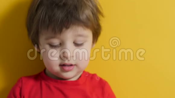 穿黄色背景的红色t恤的小男孩视频的预览图