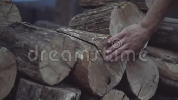 男人的手感觉到橡木柴块的木质结构储存在一堆冬天视频的预览图
