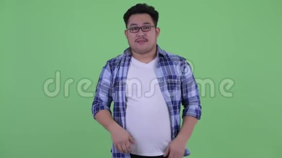 年轻体重超重的亚洲潮男在竖起大拇指和竖起大拇指之间做出选择视频的预览图