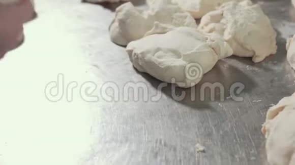 一块块面团放在不锈钢工作台上厨师揉搓面团视频的预览图