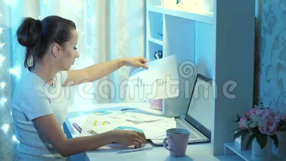 在家拿文件工作的疲惫女人视频的预览图