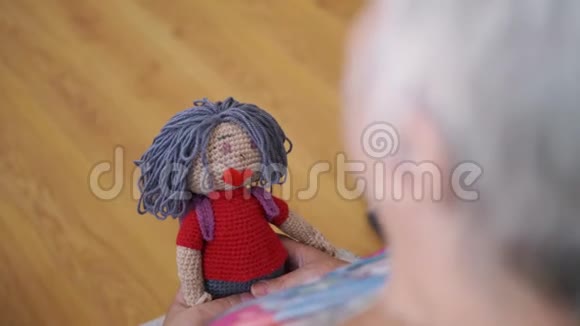 手中老年妇女手持手工编织娃娃合上老奶奶手里拿着手工娃娃视频的预览图