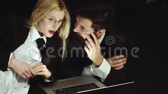 商务夫妇用笔记本电脑商人孤立英俊的男人和漂亮的女人在黑色背景工作场所视频的预览图