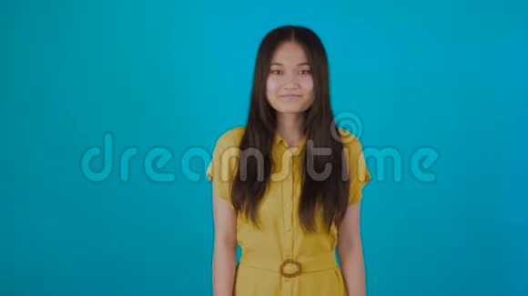 微笑的亚洲妇女显示OK手势孤立在蓝色背景确认4K视频的预览图