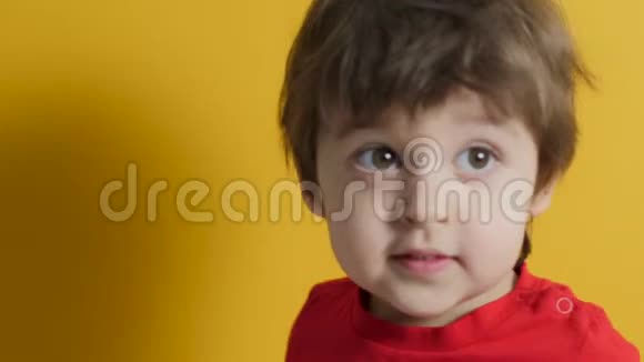 穿黄色背景的红色t恤的小男孩视频的预览图