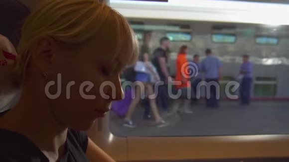 年轻女子坐在窗前的火车上等着出发视频的预览图