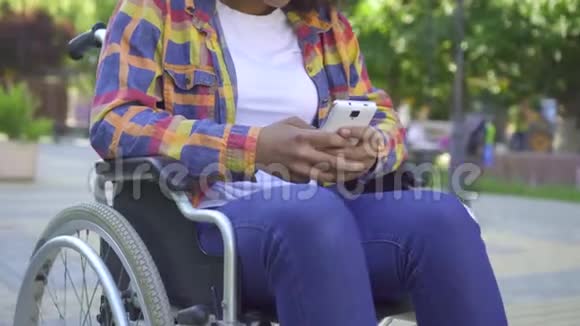 将坐在轮椅上的残疾妇女用智能手机抱起来视频的预览图