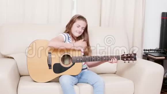少女坐在沙发上弹吉他视频的预览图