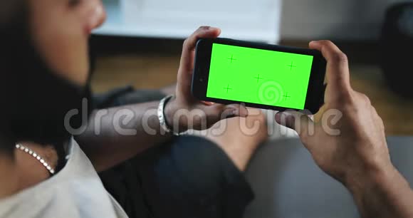 手持绿屏智能手机的人水平视频的预览图