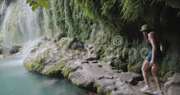女徒步旅行者在雨林中探索瀑布旅行概念视频的预览图