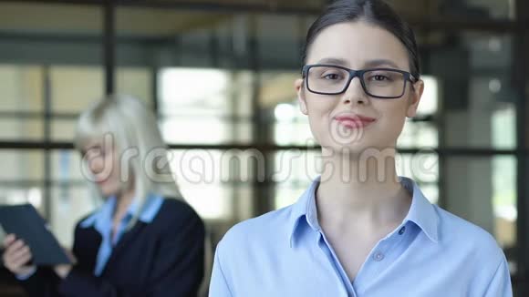 戴着相机摆姿势眼镜的聪明女人雇佣年轻的专业人士视频的预览图