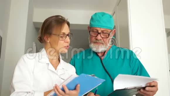 医务所的工作人员两个医生一个成熟的男人和一个年轻的女人的亲密肖像医生看着摄像机视频的预览图