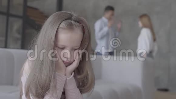 小女孩坐在前台的沙发上双手抱着头而非裔美国人的父亲和高加索人视频的预览图