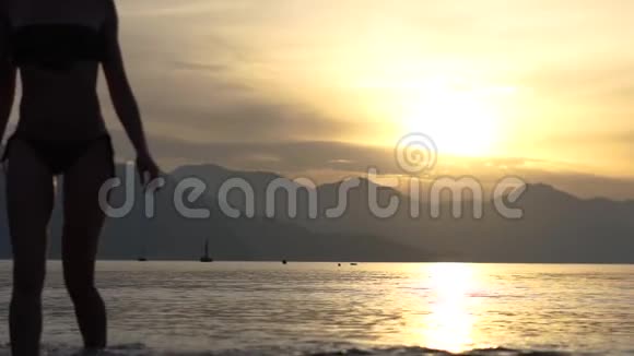 日出时从海里出来的苗条姑娘的剪影视频的预览图