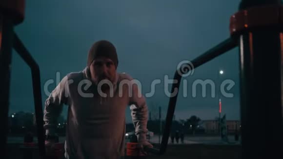 男人在夜间在户外运动场地做俯卧撑视频的预览图
