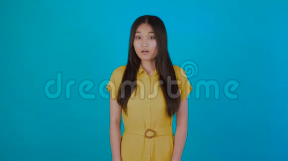 让年轻的亚洲女孩担心蓝色背景视频的预览图