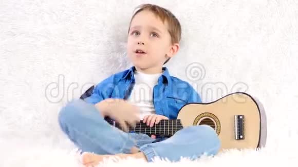 起初孩子不正确地捡起孩子们吉他然后把它翻过来开始玩微笑着视频的预览图
