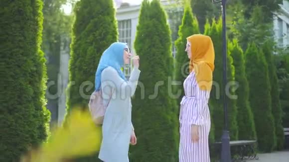 两名戴着传统围巾和眼镜的穆斯林年轻女子用手语交流视频的预览图