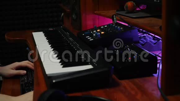音乐工程师在家庭录音室为音乐专辑创作新的热门歌曲男性手指在钢琴midi键盘上近距离手视频的预览图