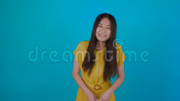年轻的亚洲女性肖像蓝色背景微笑快乐工作室拍摄4K视频的预览图
