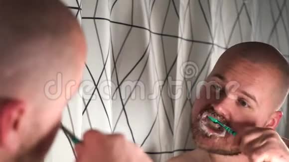 浴室里长胡子的帅哥用牙刷和清洁牙齿视频的预览图