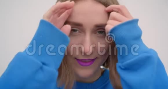年轻的短发女性的特写照片她的头发上涂着紫色的口红看着镜头背景视频的预览图