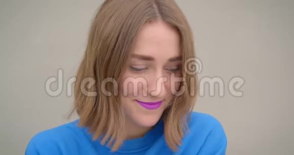 年轻可爱的深色头发的年轻女性的特写镜头她的紫色口红在镜头前欢快地摆着姿势视频的预览图