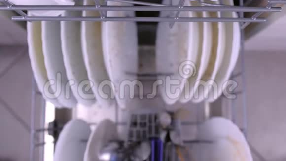 男人手把脏盘子放进洗碗机里用厨房用具推托盘视频的预览图
