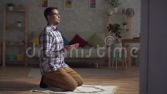 穆斯林男子坐在祈祷的位置举起双手祈祷视频的预览图