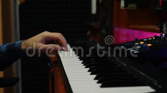 男手在家庭音乐工作室弹钢琴MIDI键盘录音师在录音室创作流行摇滚歌曲双手合拍视频的预览图