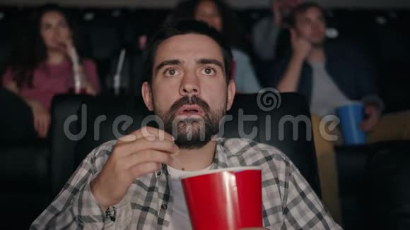 恐怖的家伙在电影院吃爆米花看震撼人心的电影视频的预览图