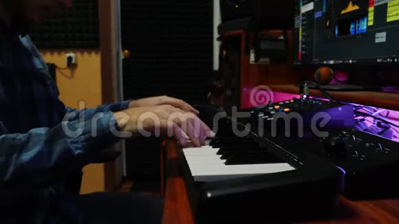 男子手在家乐室弹钢琴MIDI键盘男性手指为新专辑弹钢琴和录音歌曲音乐公司视频的预览图