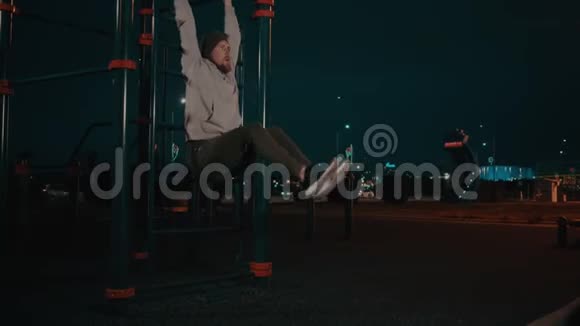 留胡子的家伙晚上在公园的训练区吊着腿视频的预览图