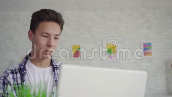穿着笔记本电脑衬衫的年轻亚裔学生视频的预览图