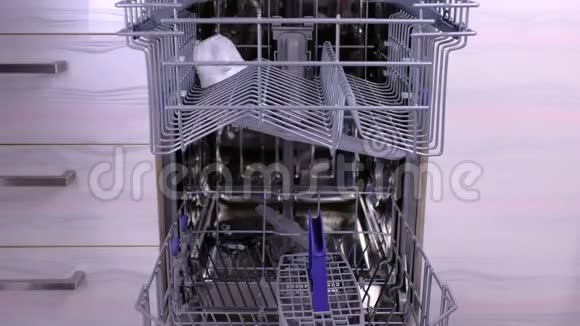 男人手在洗碗机篮子里放了一个白色的脏盘子和餐具视频的预览图