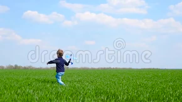 一个快乐的孩子带着飞机在草地上奔跑然后在飞行中发射飞机视频的预览图