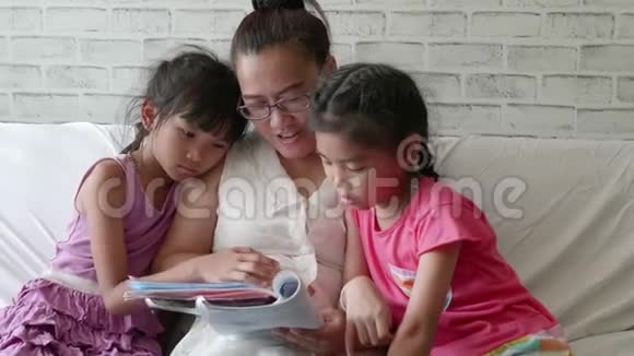年轻的母亲和女儿在家里的卧室里读故事视频的预览图