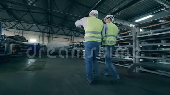 两个男工人在工厂里散步视频的预览图