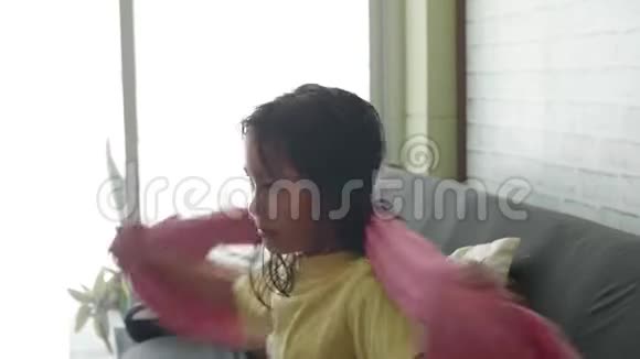 一个头发湿湿的亚洲小女孩身上铺着一条毛巾视频的预览图