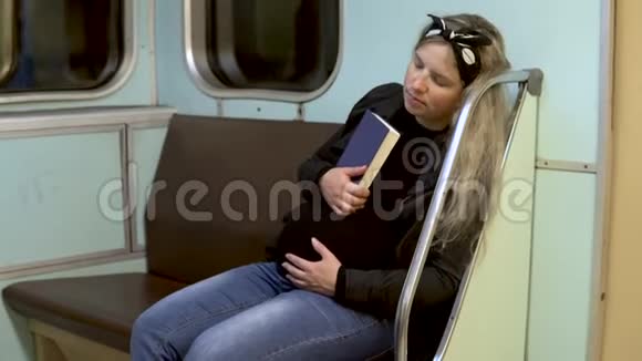 一位孕妇在地铁火车上手里拿着一本书睡着了旧地铁列车视频的预览图