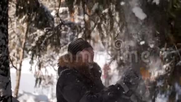 一个男人在头上摇着一根雪树枝视频的预览图