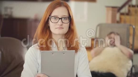 女心理学家拿着文件夹文件放在前台坐在办公室里的沮丧的年轻人视频的预览图