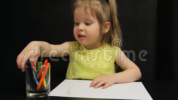小女孩用红铅笔在纸上画画视频的预览图
