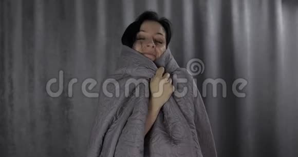 美丽的女人躺在床上躲在毯子下面在家享受着快乐的早晨视频的预览图