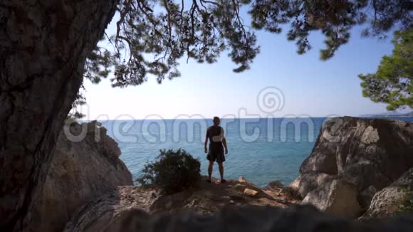 旅行者站在海边的悬崖边上视频的预览图
