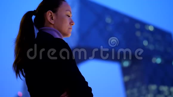 体贴的女人在夜晚欣赏现代城市景观和摩天大楼视频的预览图