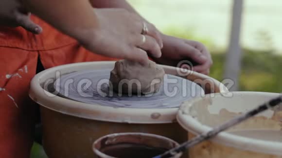 特写镜头女陶工的手把一块粘土固定在陶圈上视频的预览图