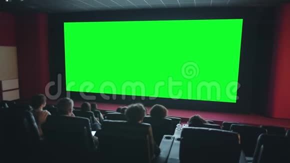 观看者在黑暗影院的绿色大屏幕共用空间欣赏电影视频的预览图