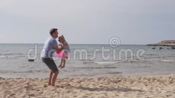 英俊的父亲把他可爱的女儿抛在空中的缓慢动作视频的预览图
